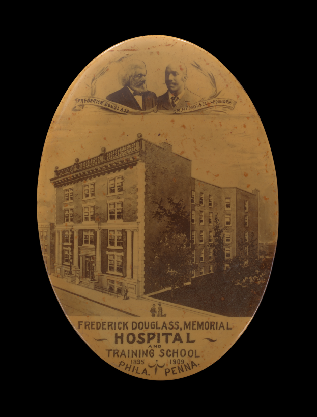 Ein altes Foto des Frederick Douglass Memorial Hospital in Philadelphia, Pennsylvania, mit zwei Personen vor einem baumbewachsenen Gebäude, auf dem ein Text steht.