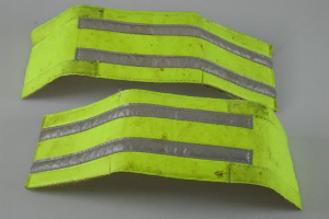 Zwei gelbe reflektierende Sicherheitswesten auf einer weißen Fläche ausgebreitet.