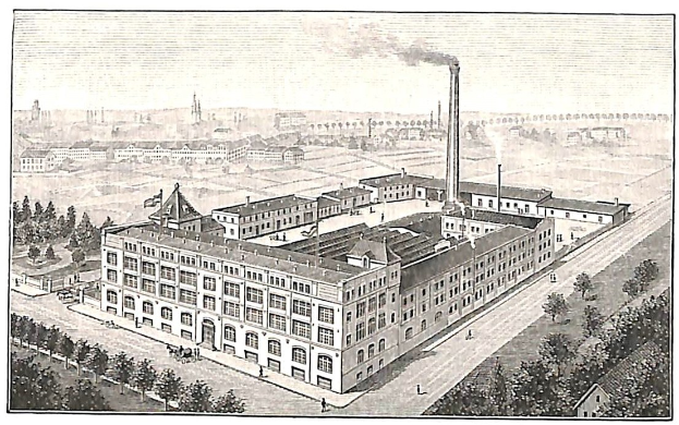 Alte Fabrik mit großem zentralen Gebäude umgeben von Bäumen und Text unten.