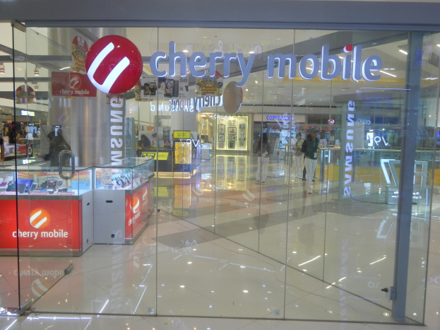 Cherry Mobile Ladengeschäft im Einkaufszentrum mit Glaswänden, Menschen, Deckenleuchten und Auslagetischen.