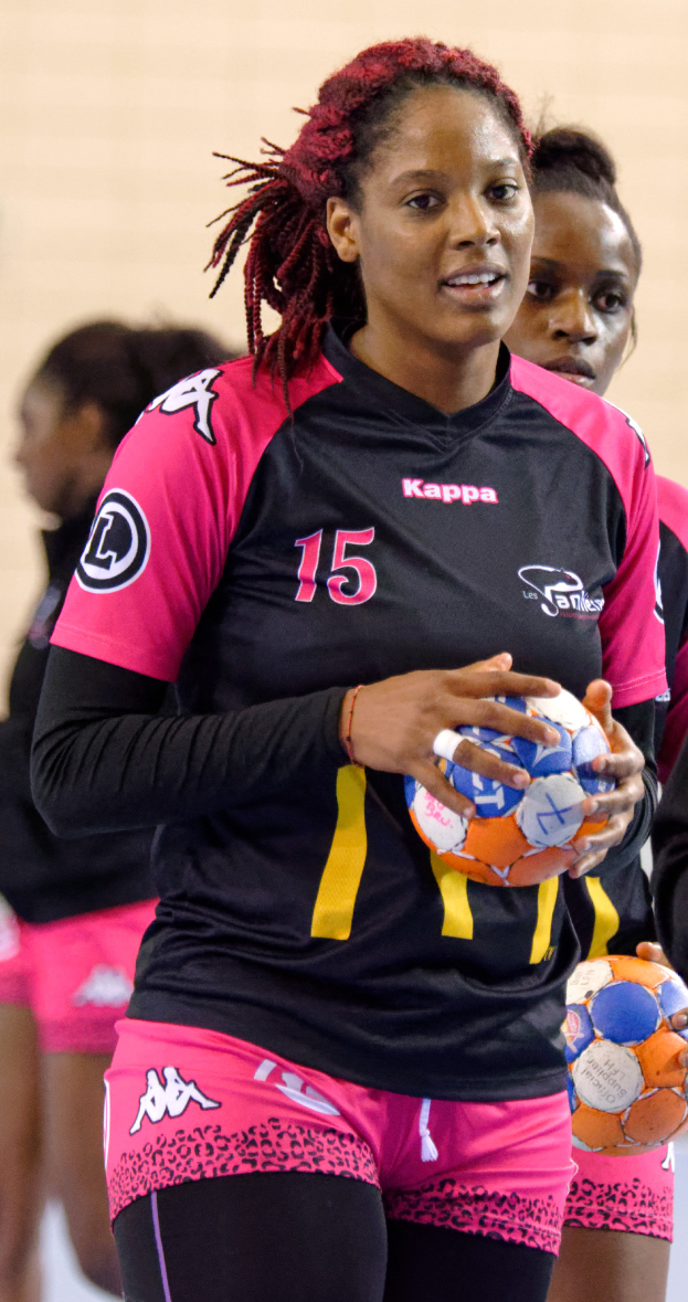 Eine Gruppe von Frauen, die zusammenstehen und jeweils einen Fußball halten, wobei die Frau in der Mitte ein menschliches Gesicht hat und direkt in die Kamera schaut.