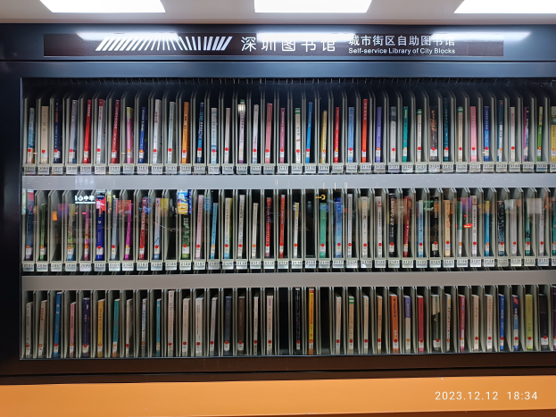 Eine gut beleuchtete Bibliothek mit hohen Bücherregalen voller Bücher, mit einer Texttafel und einem Wasserzeichen am unteren Rand, die an eine Selbstbedienungsbibliothek von Stadtblöcken erinnert.